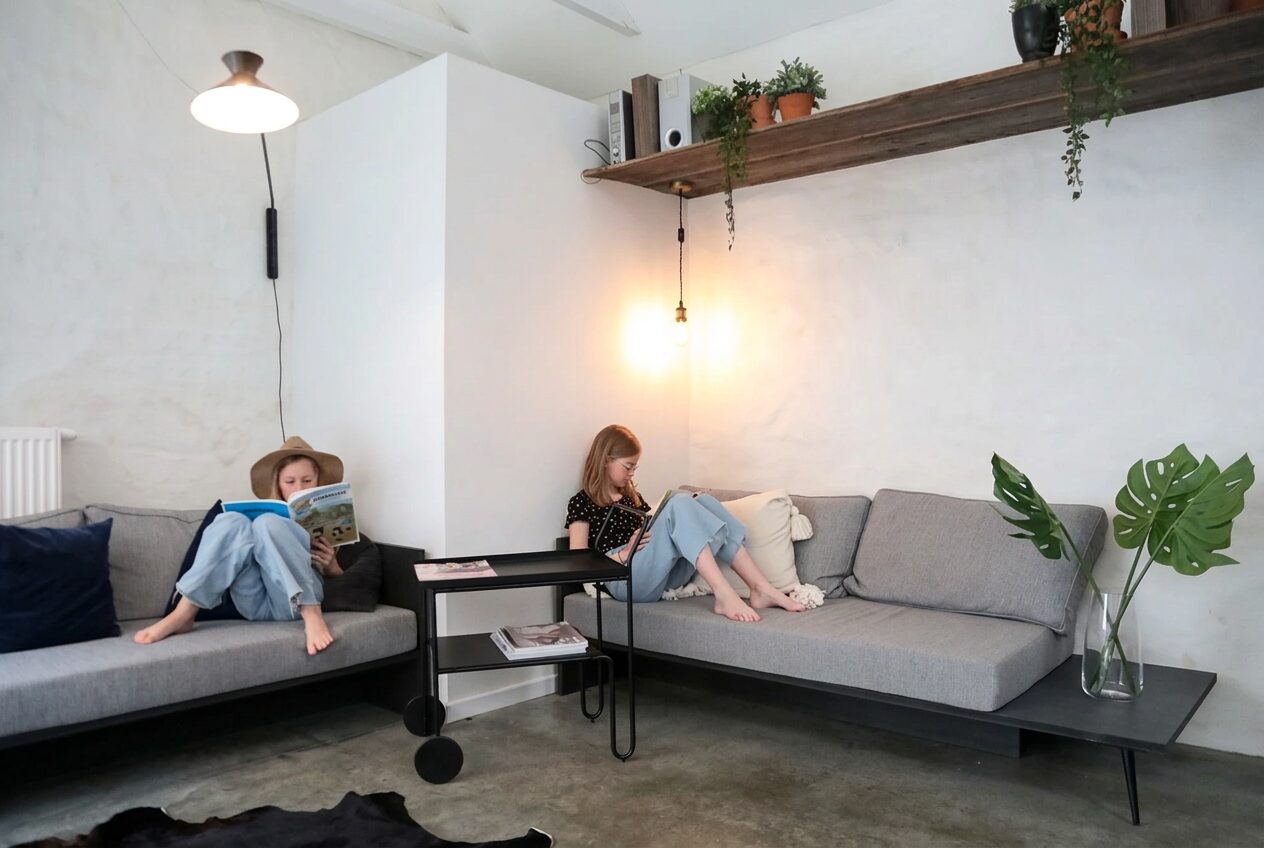 Zithoek met grijze sofa en betonvloer